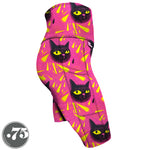 Load image into Gallery viewer, High-waisted, spandex Knee Length pocket shorts. The fabric has a bright pink background with yellow triangle shapes and large hand drawn cat heads with yellow eyes.
