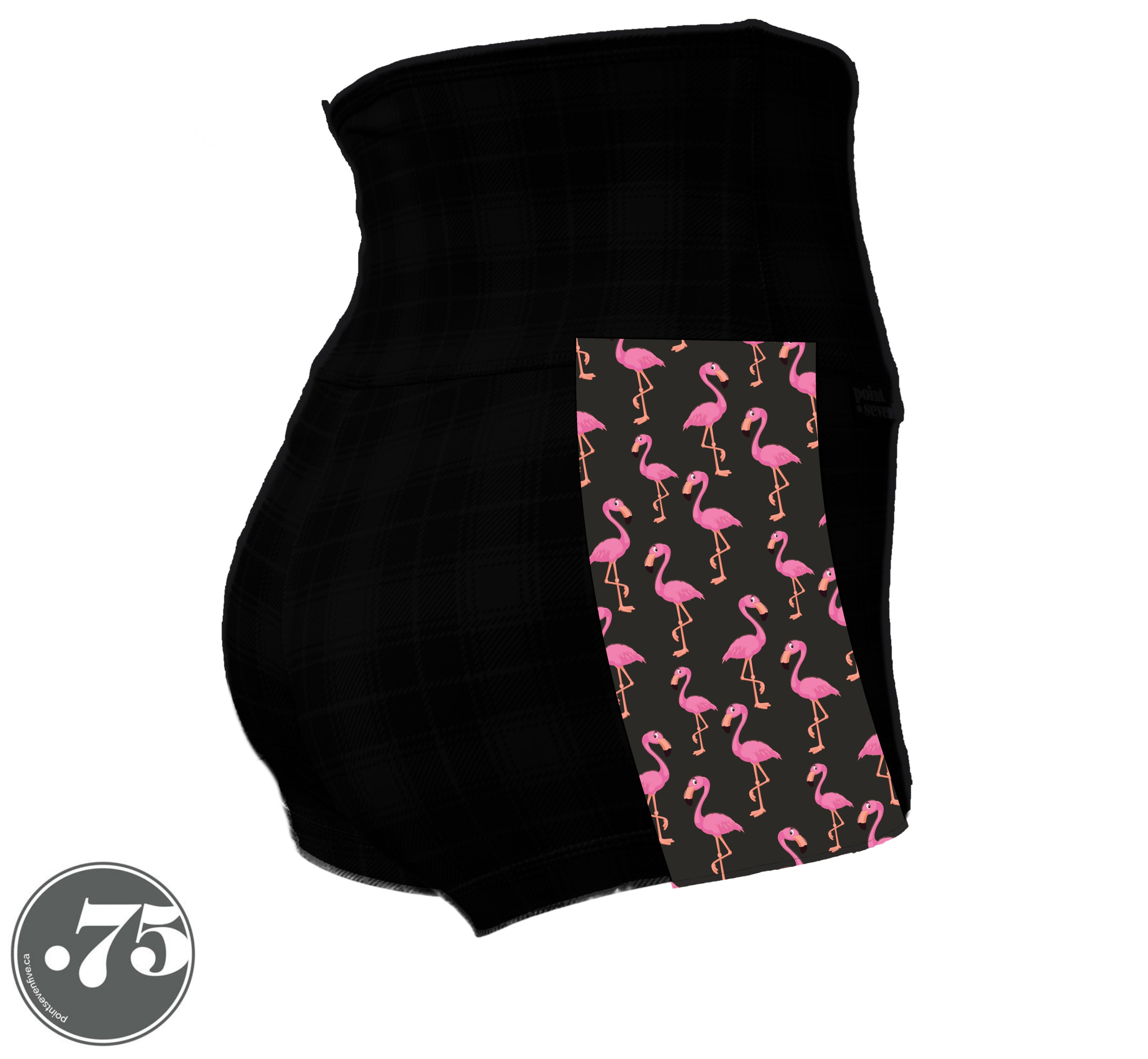 A pair of black spandex shorts against a white background. The shorts are a short length with approx 2” inseam and have a panel on the side with a pocket, the panel has fabric with a charcoal grey background with scattered cartoon pink flamingos on it.