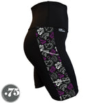 Load image into Gallery viewer, A pair of black spandex skate length shorts on a mannequin, the leggings have a 3.5” wide stripe down the side that has a printed fabric with rollerskates, helmets, stars &amp; knee pads. The graphics are in the colours of the Ace Pride Flag, Black, Grey, White &amp; Purple.
