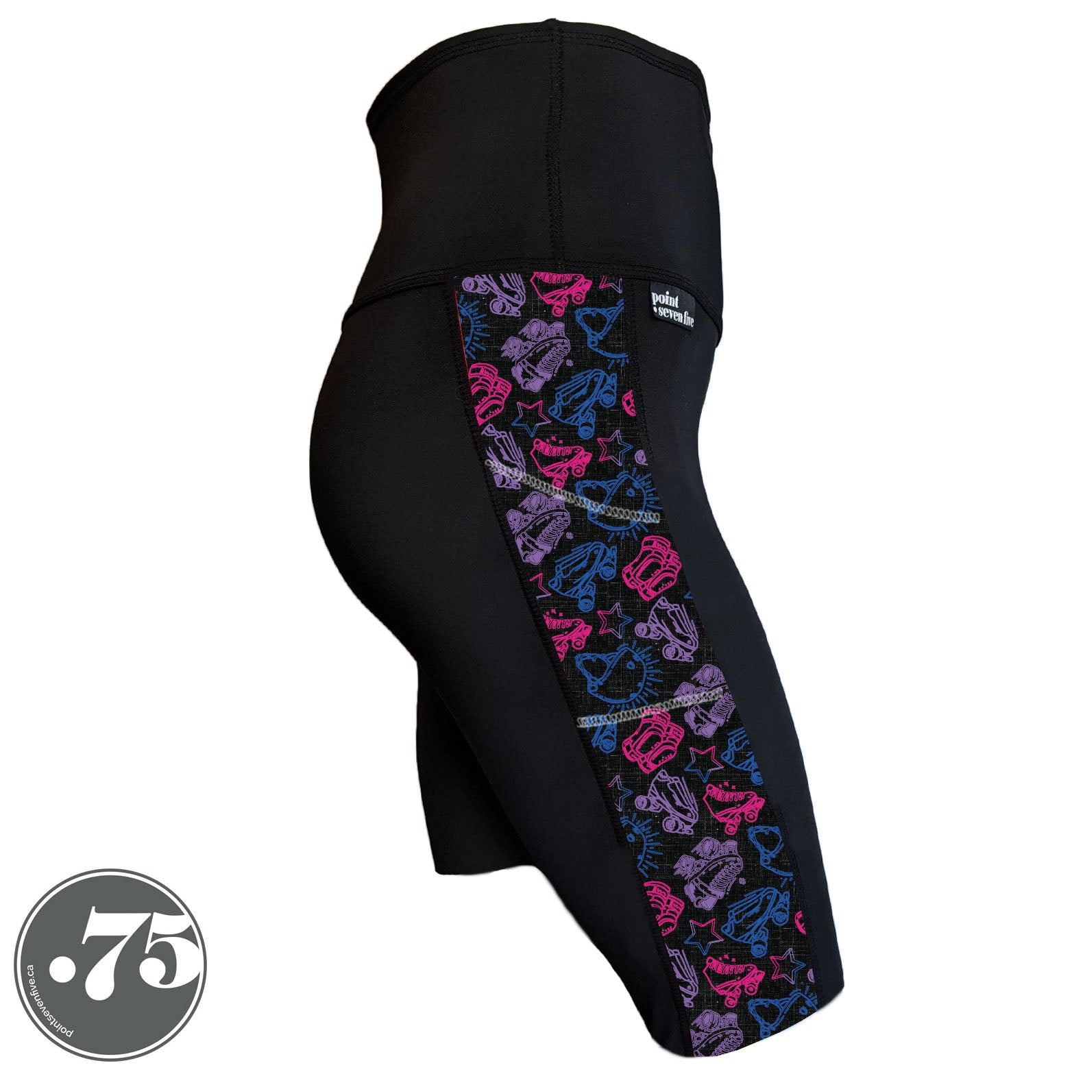 A pair of black spandex knee length shorts on a mannequin, the leggings have a 3.5” wide stripe down the side that has a printed fabric with rollerskates, helmets, stars & knee pads. The graphics are in the colours of the Bi Pride Flag pink, purple and blue