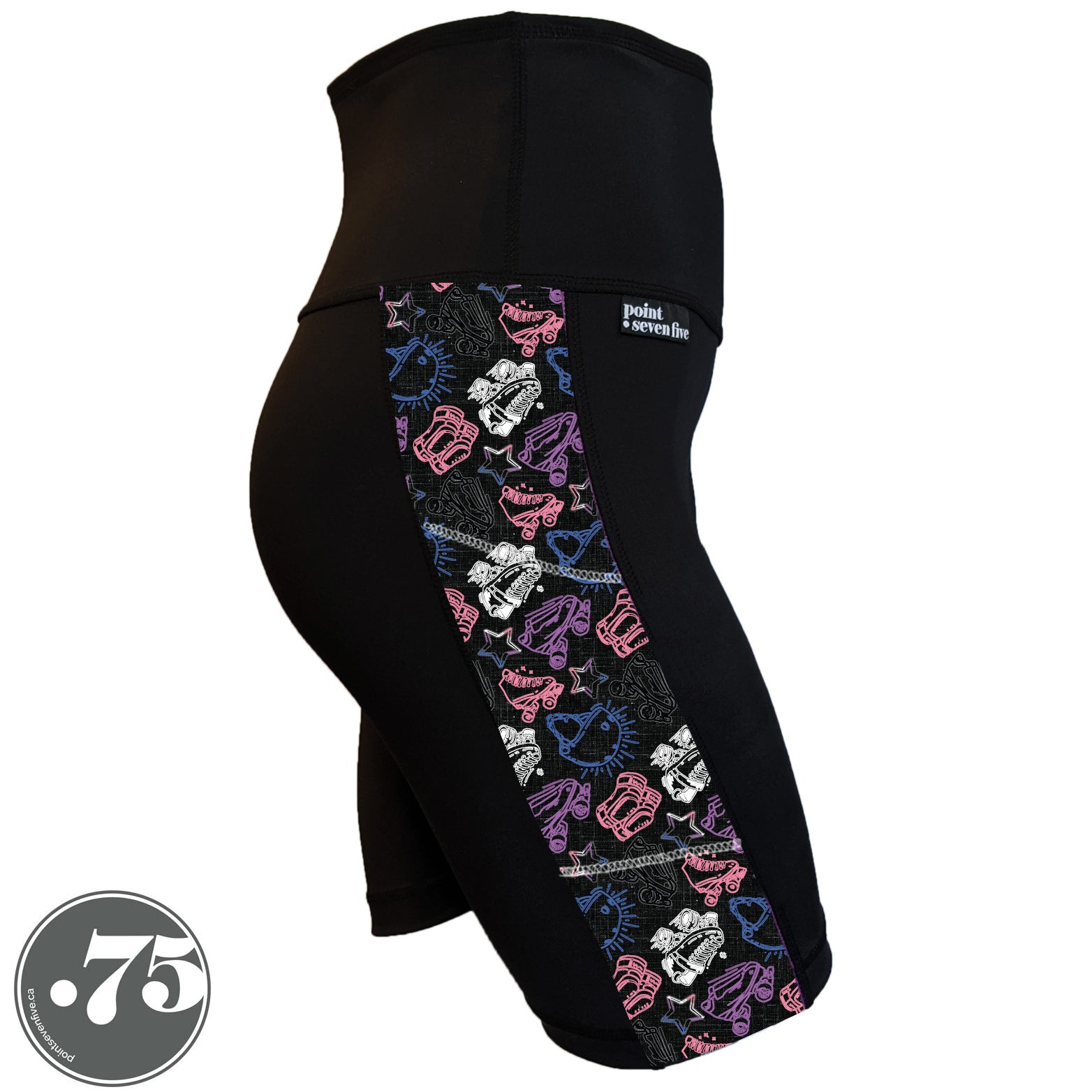 A pair of black spandex skate length shorts on a mannequin, the leggings have a 3.5” wide stripe down the side that has a printed fabric with rollerskates, helmets, stars & knee pads. The graphics are in the colours of the Gender Fluid Pride Flag colours white, pink, blue and purple.