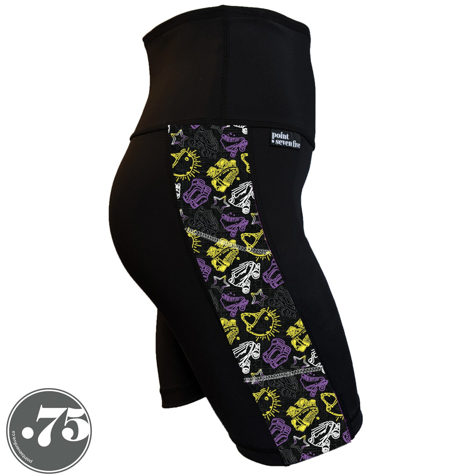 A pair of black spandex skate length shorts on a mannequin, the leggings have a 3.5” wide stripe down the side that has a printed fabric with rollerskates, helmets, stars & knee pads. The graphics are in the colours of the Non-Binary Pride Flag, white, black, purple and yellow. 