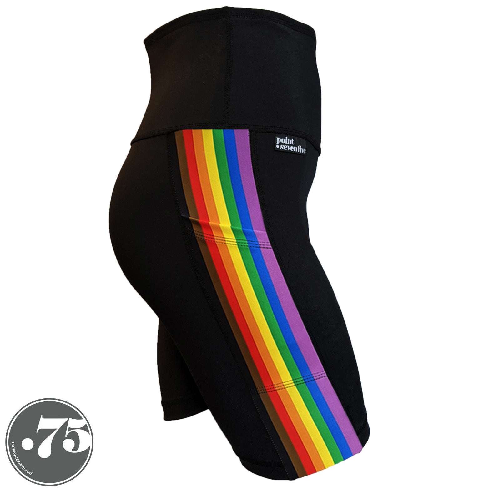 A pair of black spandex skate length shorts on a mannequin, the leggings have a 3.5” wide stripe down the side that has a printed fabric with the stripes of the Philadelphia Pride Flag vertically, the stripes are black, brown, red, orange, yellow, green, blue & purple.